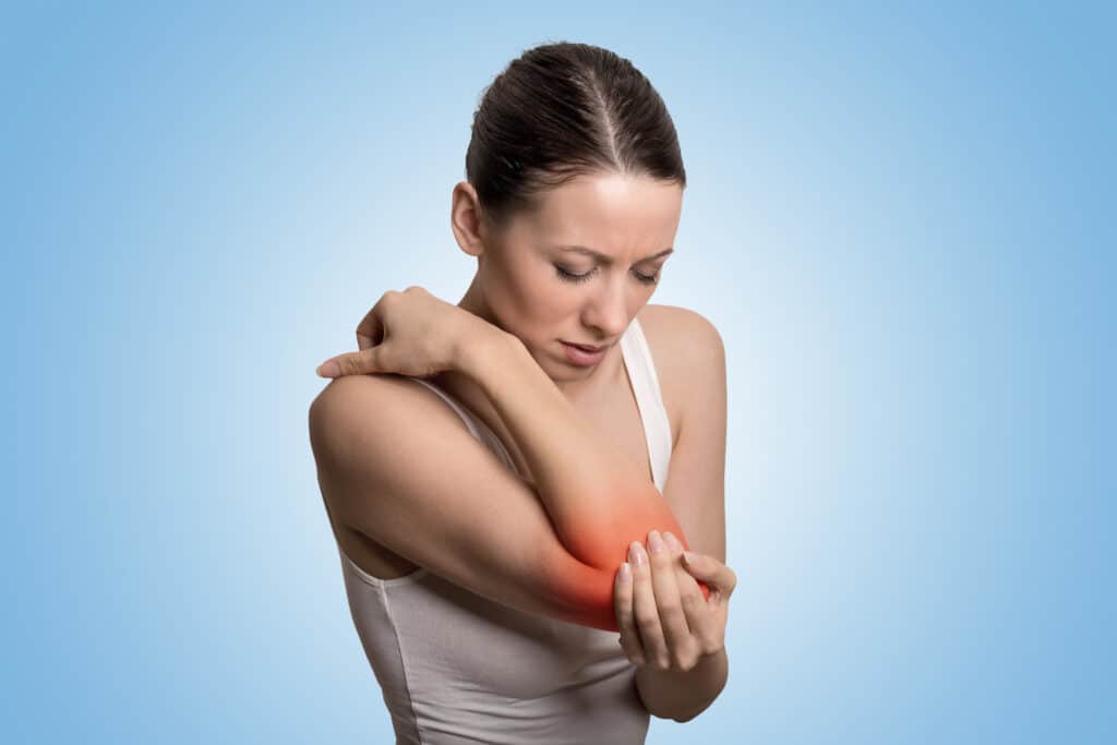 Arthrose du coude indiquée par une tâche rouge sur le coude d'une jeune femme